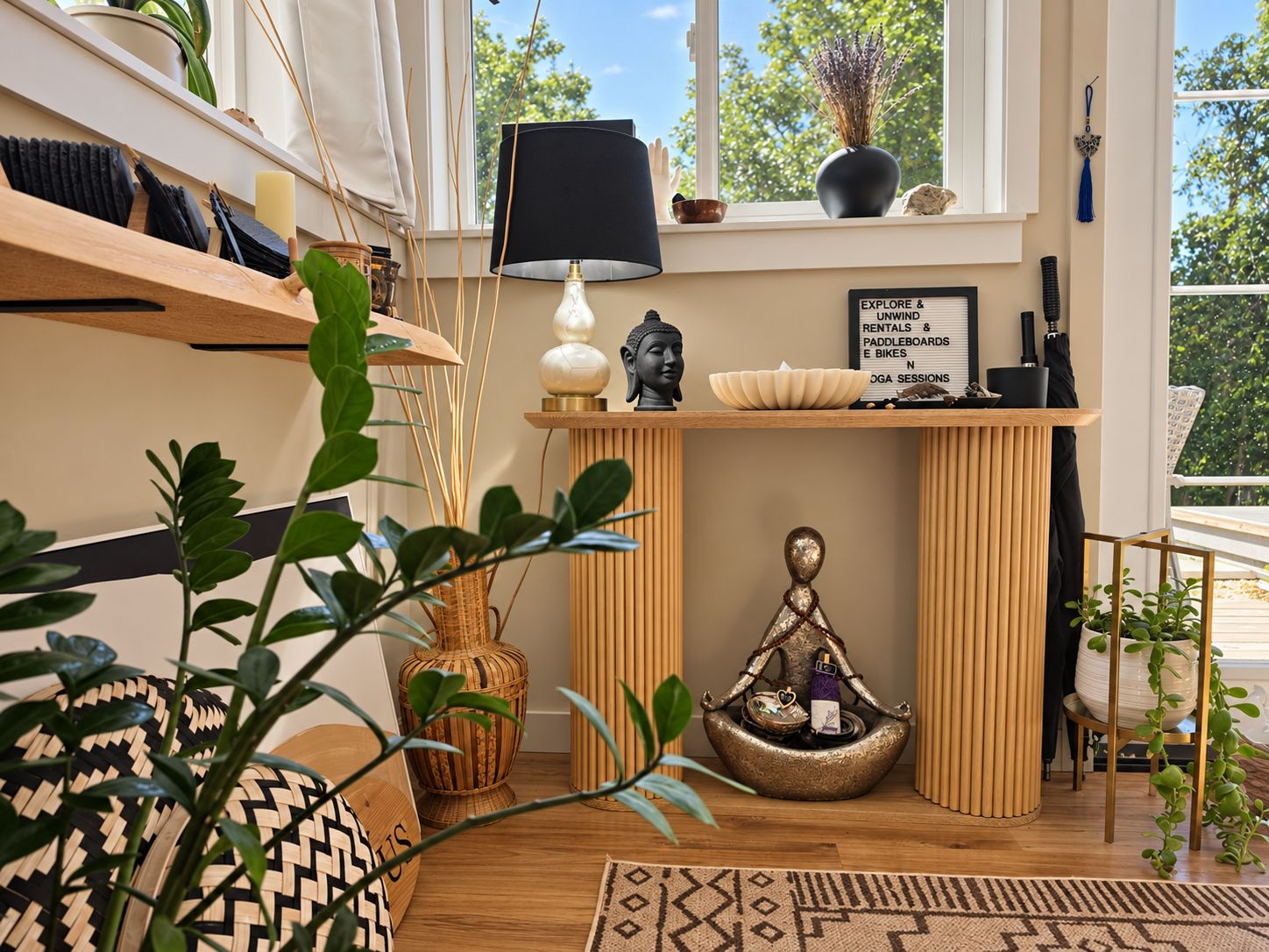 Une pièce avec une étagère en bois, une statue de Bouddha, une lampe et un panneau d’information sur les locations et les activités proposées.