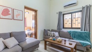 A living room with two sofas, a coffee table, and a window with curtains. - Daya 2BR Apartment In Batroun (Batroun)