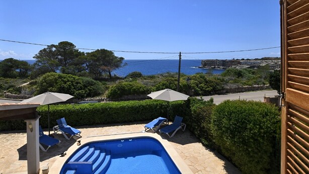 A pool area with lounge chairs and umbrellas, overlooking a coastal landscape. - Holiday Home 'Amarador' with Private Pool, Wi-Fi and Air Conditioning (Santanyí)