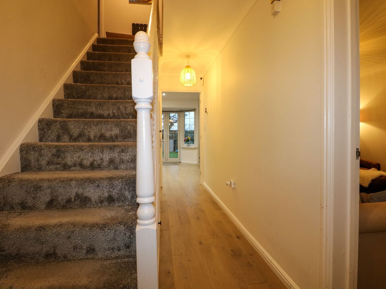 A staircase with carpeted steps and a white balustrade leading to a door.