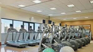 A gym with treadmills, elliptical machines, and exercise balls.