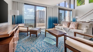 A spacious living room with a balcony, a sofa set, a coffee table, and a TV.