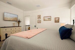 A bedroom with a bed, a dresser, a mirror, and framed artwork on the wall. - Dog-Friendly Farmhouse – 4BR Fenced Yard, Porch, Walkable to Restaurants & Cafes (Tampa)