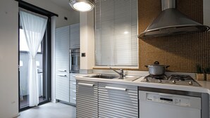 Una cocina moderna con horno empotrado, estufa y lavavajillas.
