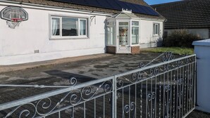 A house with a solar panel roof, a basketball hoop, and a gated entrance. - Maes Hyfryd (Clynderwen)