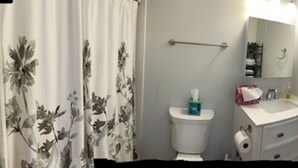 Un bagno con il water, un lavandino e uno specchio.