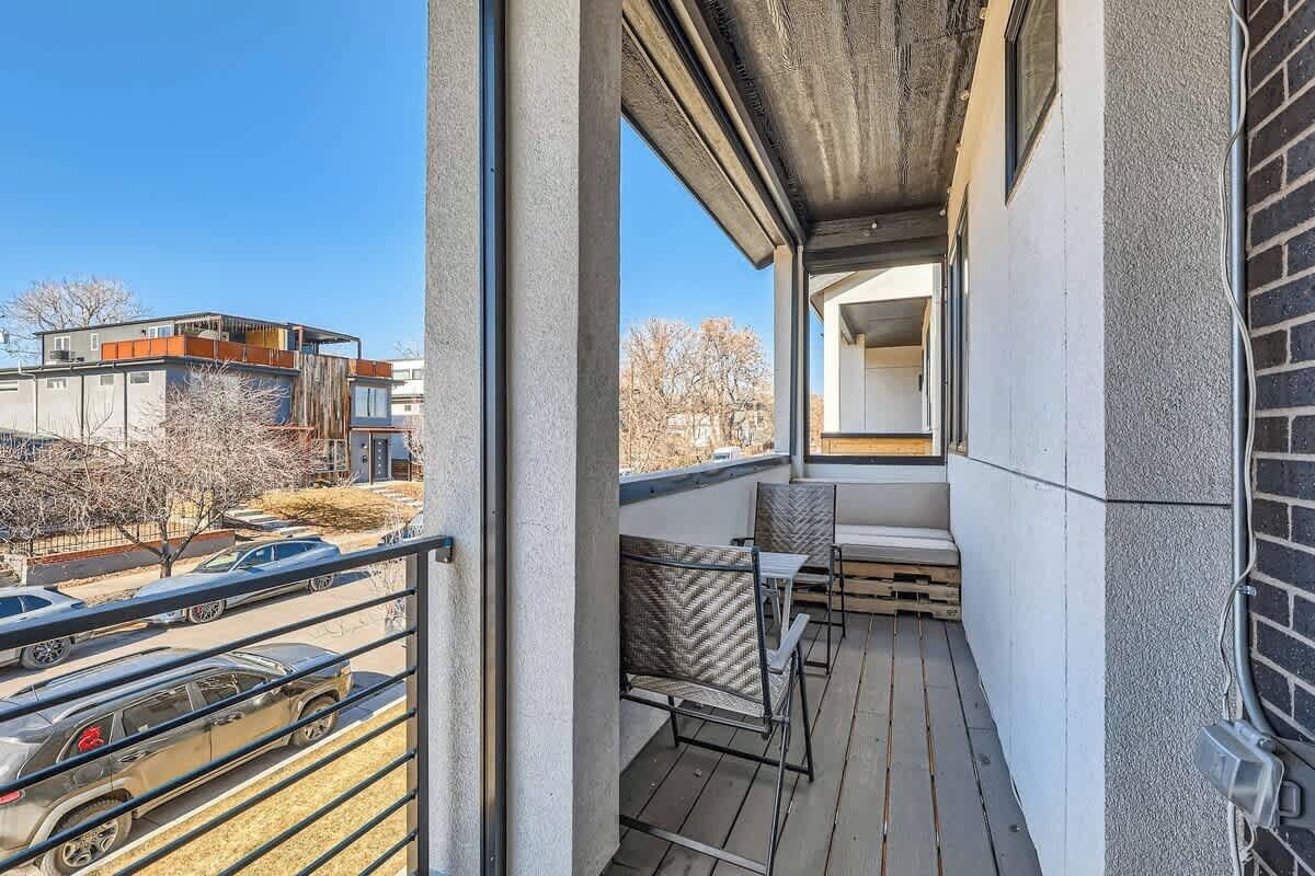 A balcony with a view of parked cars and buildings.