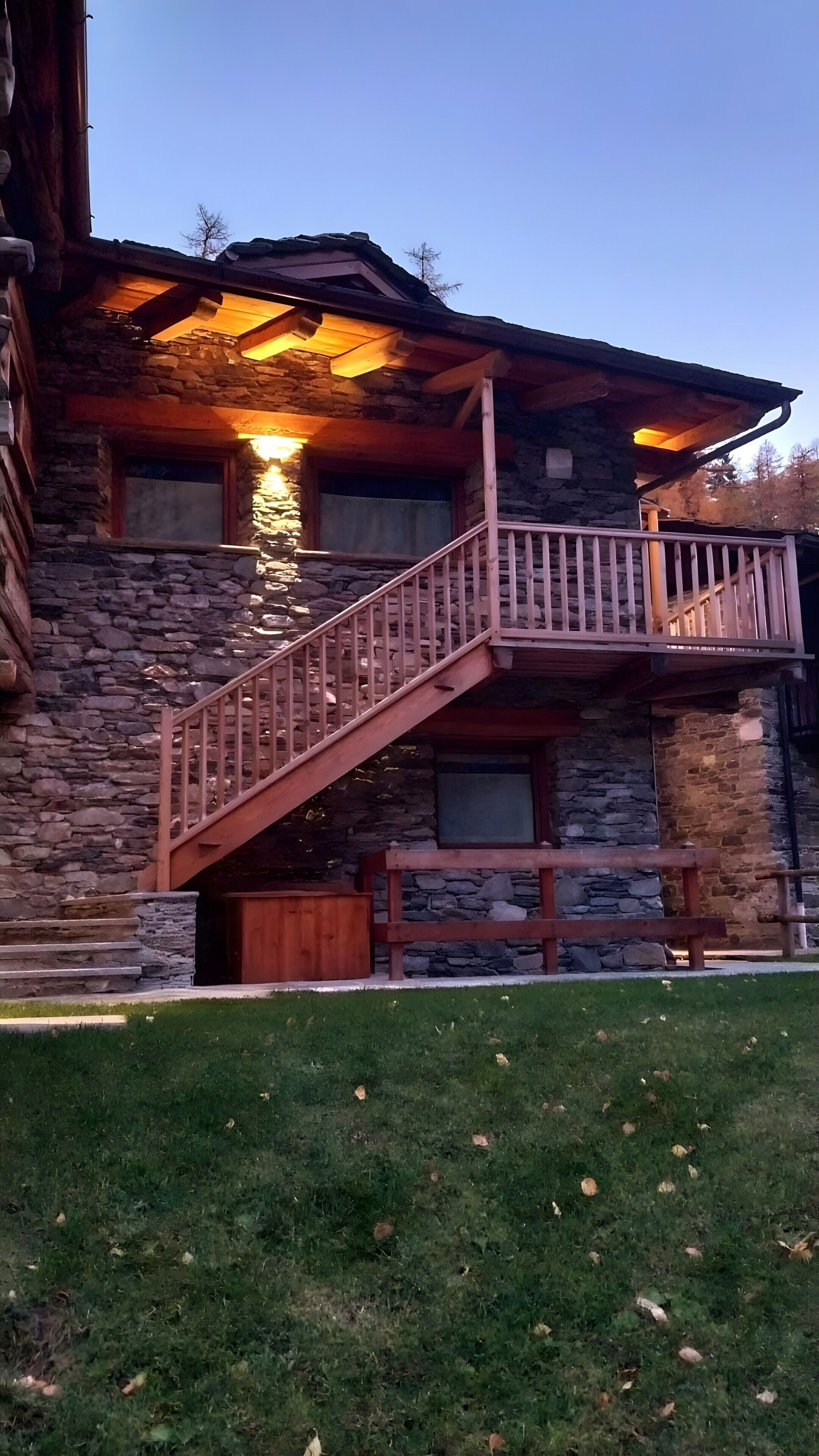 Un bâtiment en pierre avec un escalier et un balcon en bois.