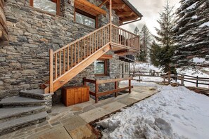 Un edificio in pietra con una scala e un balcone in legno.
