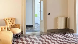 Una habitación con suelo a cuadros, un radiador y dos sillones.