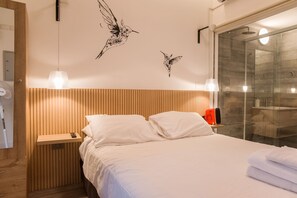 A hotel room with a bed, bedside table, and a wall-mounted heater. - Stylish Studio in Bellavista with Great Amenities (Providencia)