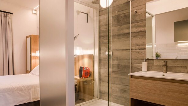A modern bathroom with a glass-enclosed shower, a wooden vanity, and a large mirror. - Stylish Studio in Bellavista with Great Amenities (Providencia)