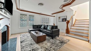 Una sala moderna con un sofá seccional, una mesa de centro y una chimenea.