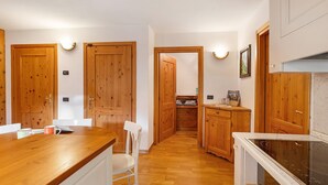 A kitchen with wooden cabinets, a white countertop, and a built-in stove.