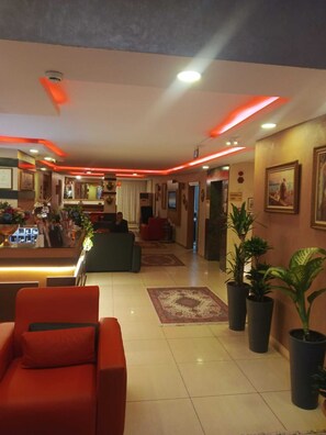 A hotel lobby with a reception desk, seating area, and potted plants. - HOTEL EFENDİ (Istanbul)