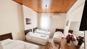 A hotel room with a wooden ceiling, a bed with a towel, a small sofa, a mirror, and a dresser with flowers. - HOTEL EFENDİ (Istanbul)