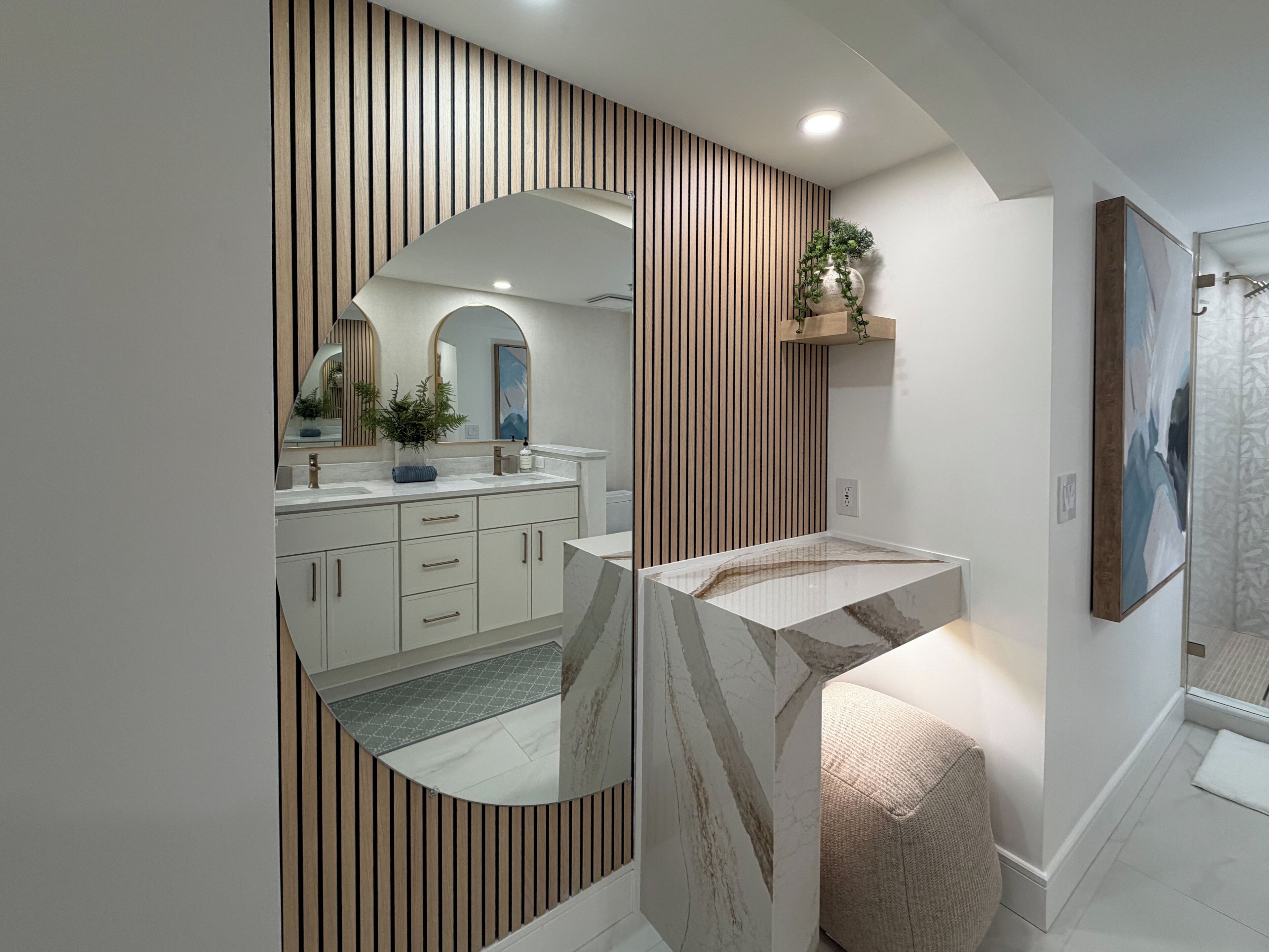 A modern bathroom with a vanity, mirror, and a shower area.