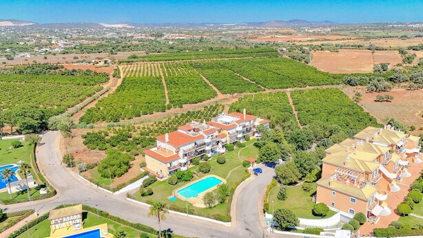 Una extensa propiedad con varias construcciones, una piscina y amplios viñedos.