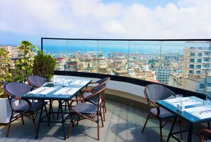 Una terrazza sul tetto con tavolo e sedie, che offre una vista panoramica sulla città.