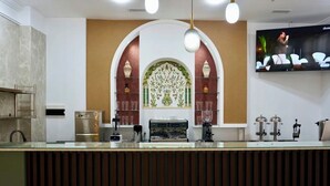 Una cucina moderna con una macchina da caffè, una TV montata a parete e piastrelle decorative.