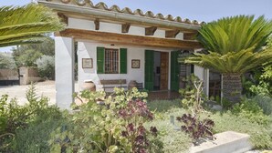 A house with a porch, green shutters, and a garden with various plants. - Villa 'Valls' with Private Pool, Wi-Fi and Air Conditioning (Montuïri)