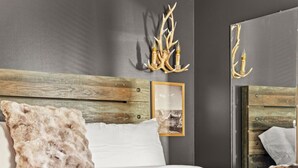 A modern bedroom with a wooden headboard, a large bed with white and brown bedding, and a framed picture on the wall. - Countryside Views | Sleeps 20, Hot Tub, Fire Pit (Theodosia)
