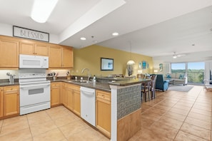 A modern kitchen with wooden cabinets, a built-in microwave, and a large island. - ⛱️Easy Walk to Beach | Pet Friendly | Great Amenities | Oceanwalk 7-404⛱️ (New Smyrna Beach)