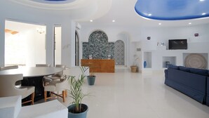 Eine moderne Hotelhalle mit einem runden Esstisch, Sofas und einer Rezeption.
