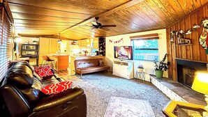 Una sala de estar acogedora con un sofá de cuero, chimenea y televisor.