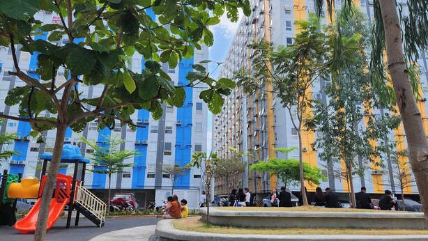 A residential building with multiple floors, balconies, and a playground with a slide. - URBAN DECA ORTIGAS SM EAST PASIG (Pasig)