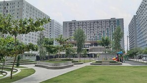 A modern urban residential area with high-rise apartment buildings, a central park with a playground, and a well-maintained lawn. - URBAN DECA ORTIGAS SM EAST PASIG (Pasig)