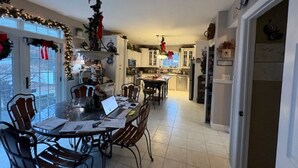 Eine geräumige Küche mit Essbereich, ausgestattet mit einer großen Kochinsel, modernen Geräten und Weihnachtsdekorationen.