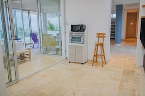 Una cocina moderna con microondas, horno y taburetes de madera.
