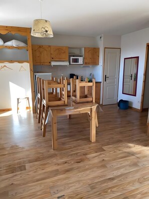 Une cuisine spacieuse dotée de meubles en bois, d’un four à micro-ondes et d’un coin repas avec une table et des chaises en bois.