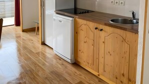 A kitchen with wooden cabinets, a microwave, a dishwasher, and a sink.