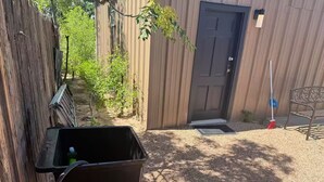A small outdoor area with a metal bench, a door, and a metal table. - Breakfast included/dartboard (Carlsbad)