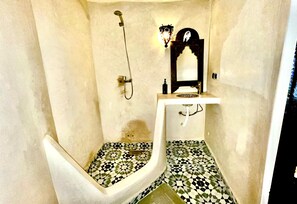 Een douche, handdoeken, zeep, toiletpapier