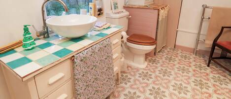 A bathroom with a sink, toilet, and a cabinet.