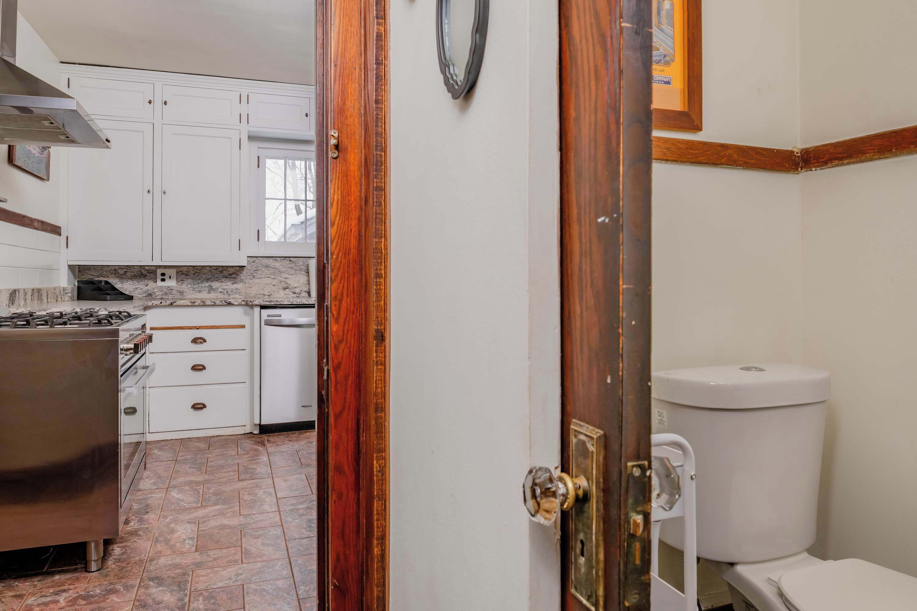 A kitchen with white cabinets, a stove, and a dishwasher.