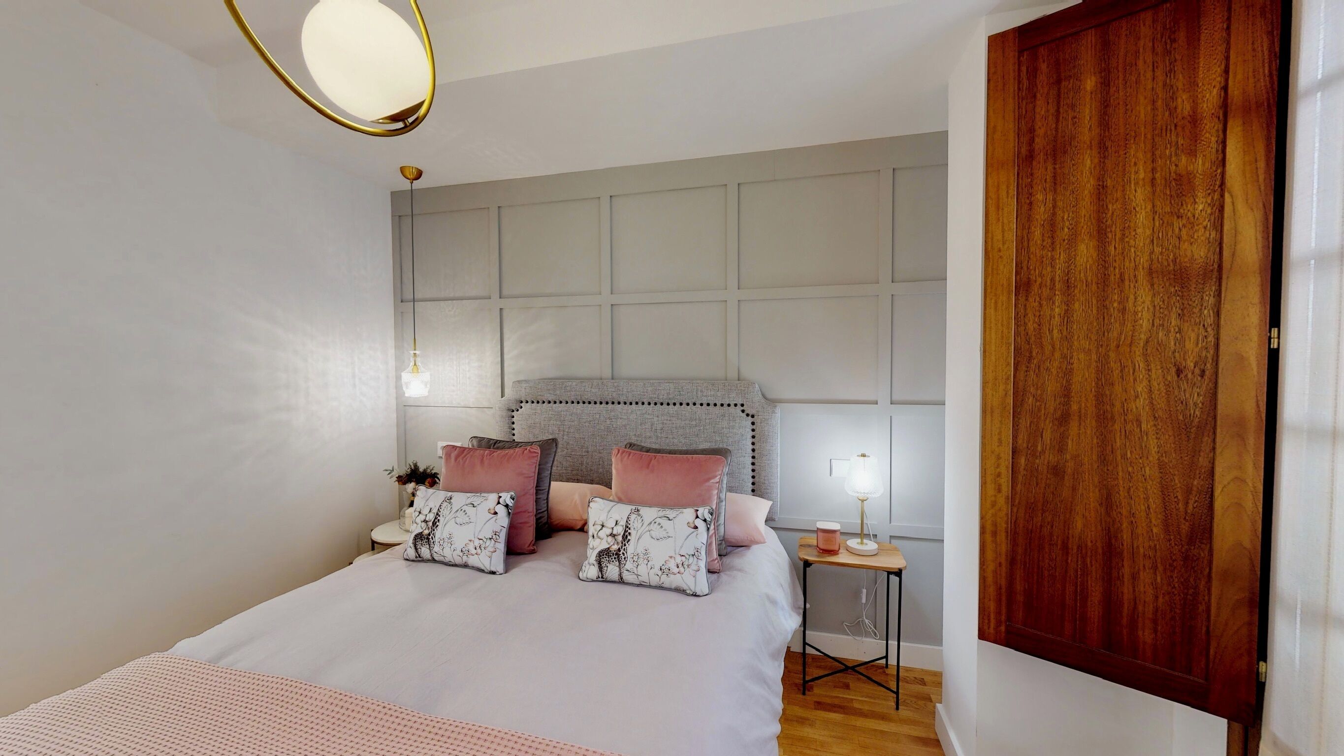 Une chambre à coucher avec un lit, une table de chevet, une lampe et une porte en bois.