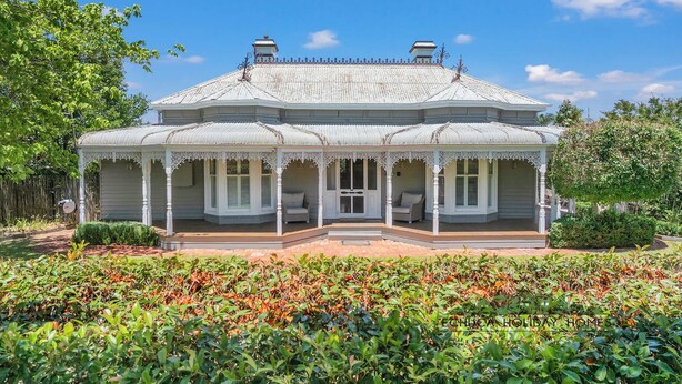 A large, two-story house with a covered porch and a garden in front. - Central Charm - the best of Echuca living! (Echuca)