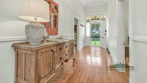 A hallway with wooden flooring, a wooden cabinet with drawers, a lamp, and a painting on the wall. - Central Charm - the best of Echuca living! (Echuca)