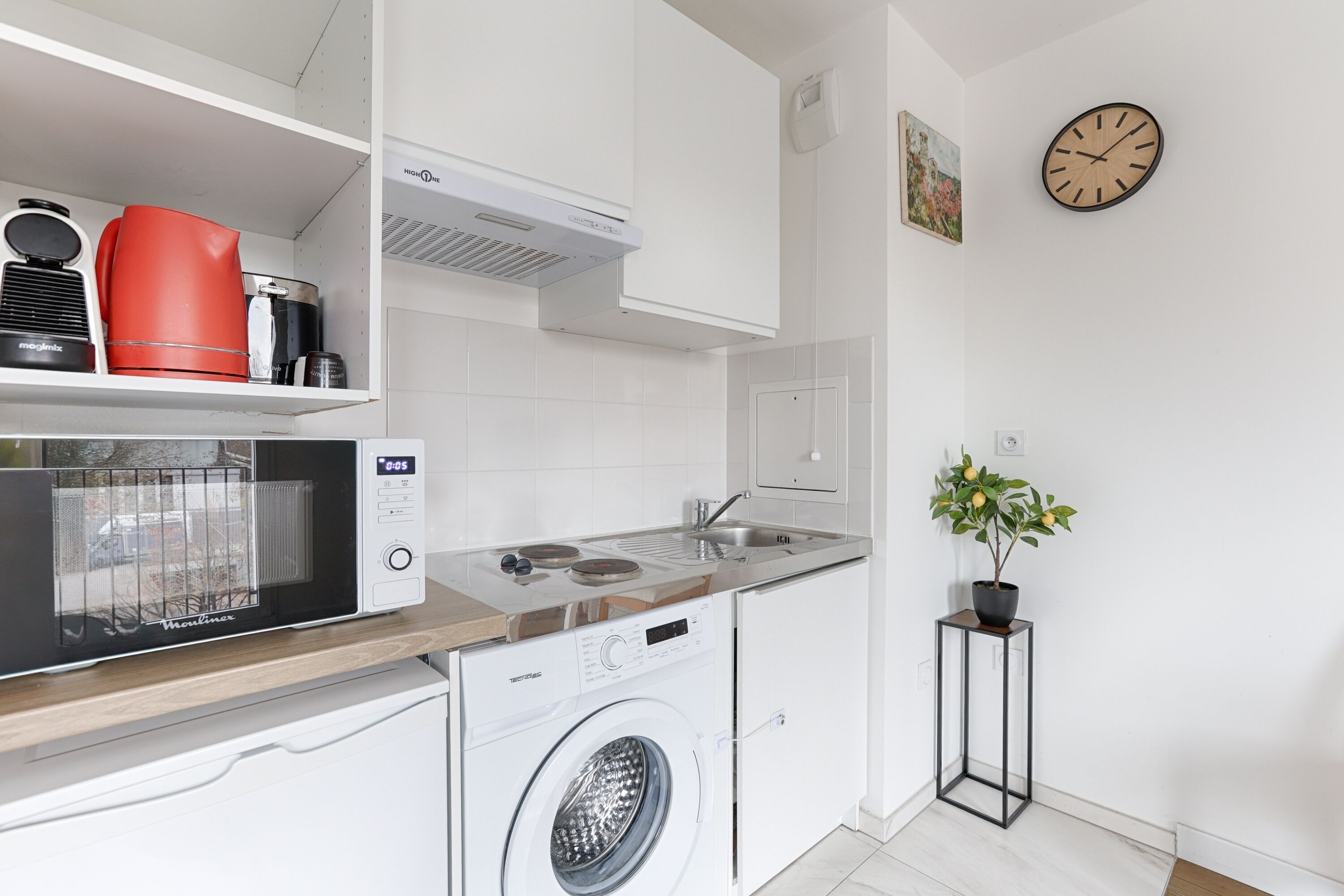 A modern kitchen with a microwave, toaster, and washing machine.