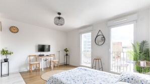 Ein modernes Schlafzimmer mit einem großen Bett, einem Schreibtisch und einem Fernseher.