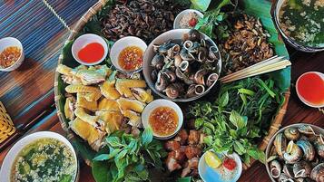 A variety of dishes and condiments arranged on a wooden table, suggesting a meal setting.