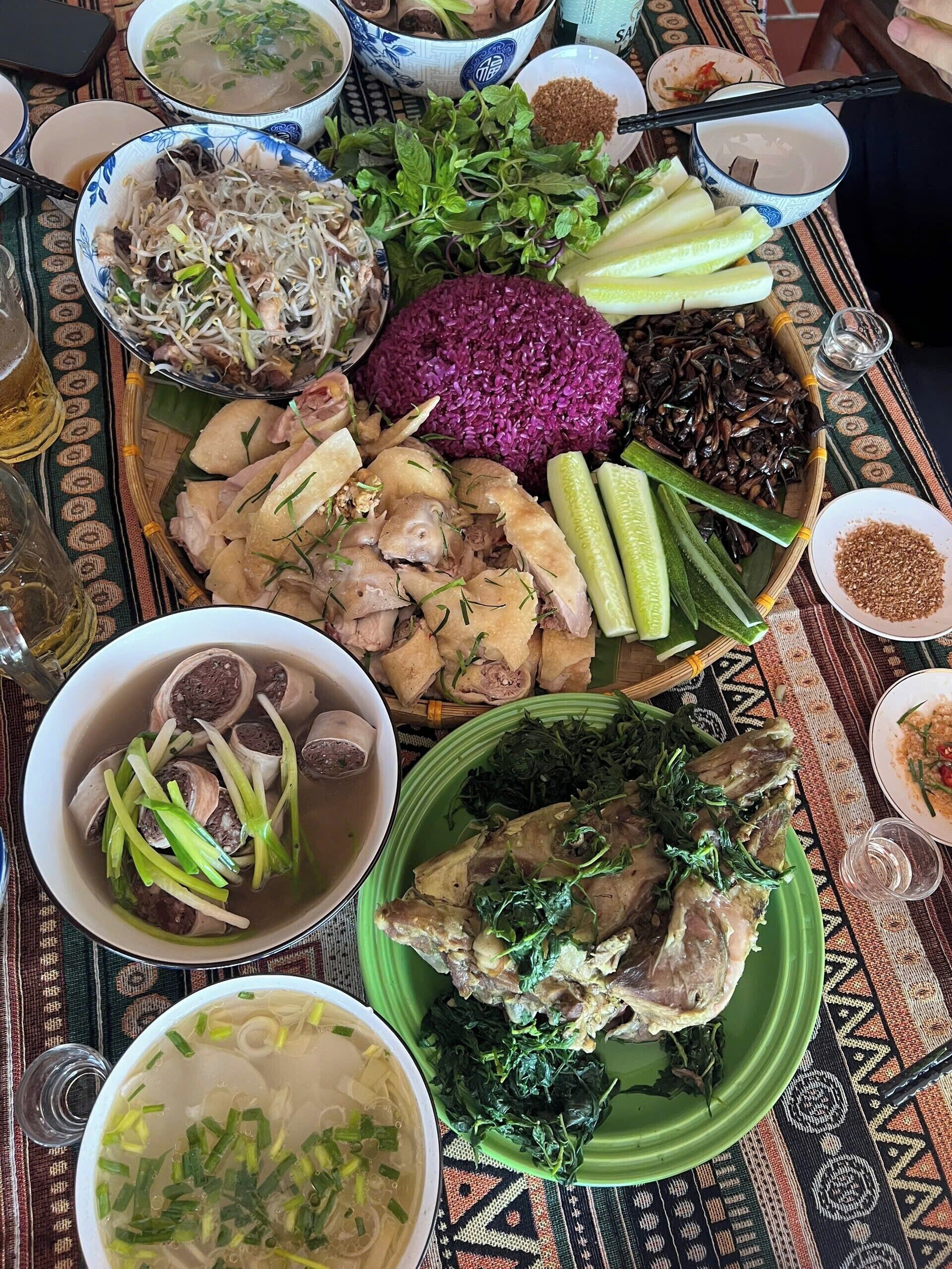 A table with various dishes including bowls of soup, plates of meat, and vegetables, suggesting a meal setting.