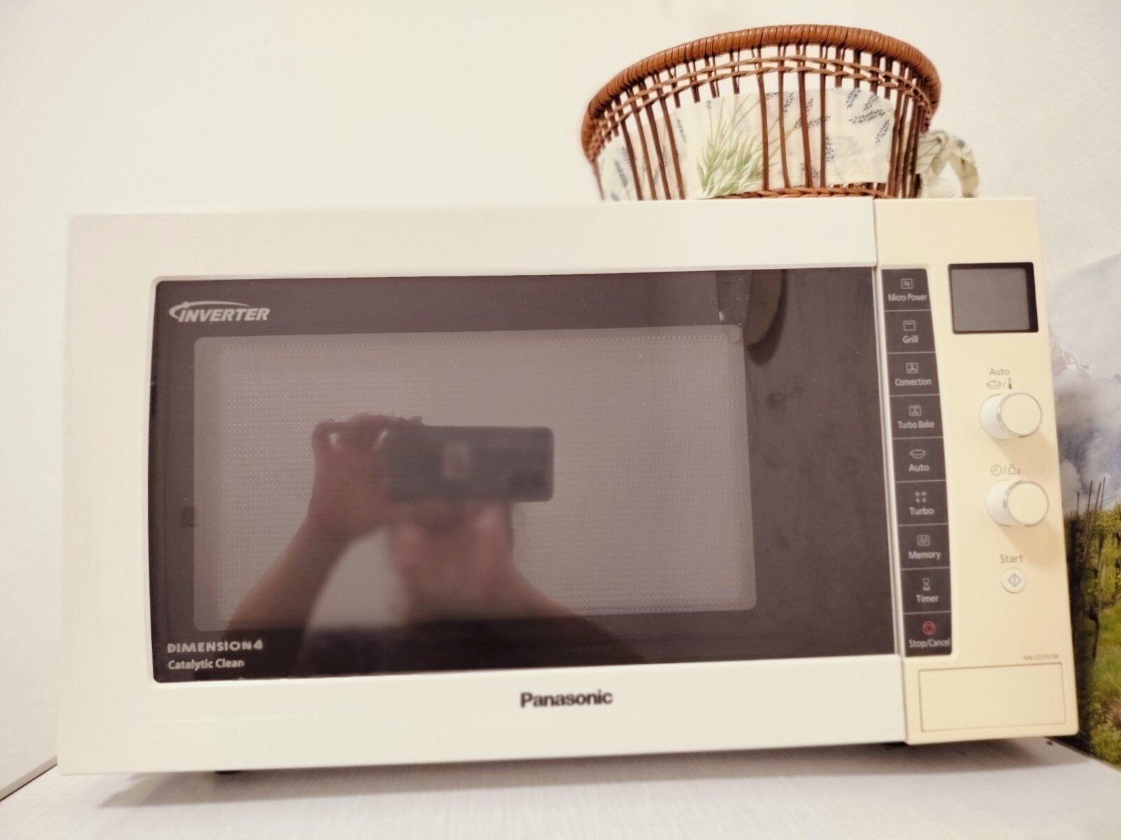 Un horno microondas Panasonic con una cesta encima.