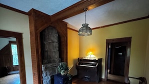 A spacious living room with a stone fireplace, wooden beams, and a chandelier. - New River Gorge National Park Sunsets, Rafting and Hiking trails. (Lansing)