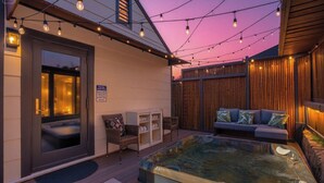 Zona de spa con hidromasaje, asientos e iluminación con luces colgantes.