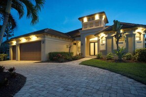 A two-story house with a garage, a covered entryway, and a well-maintained lawn. - Sunshine Pearl Residence (Cape Coral)